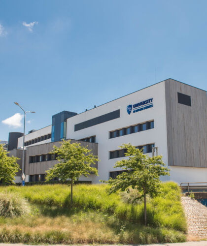 Gebouw HZ Groene Woud met bomen in de voorgrond