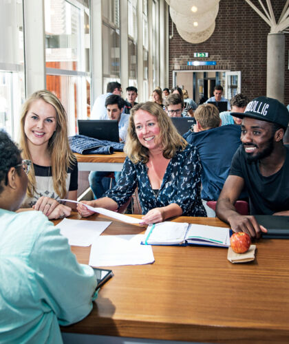 Docenten en studenten in gesprek aan een tafel